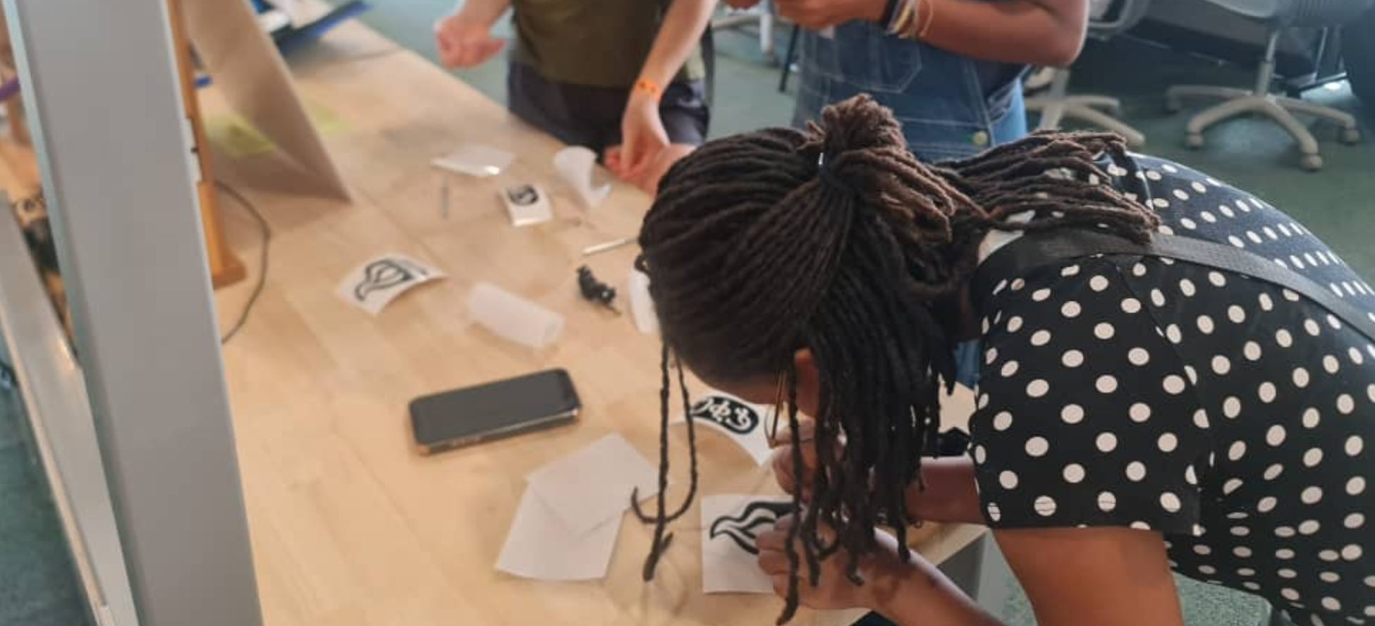 photo of Ethiopian girl working on a black and white vinyl sticker with an image of a flame