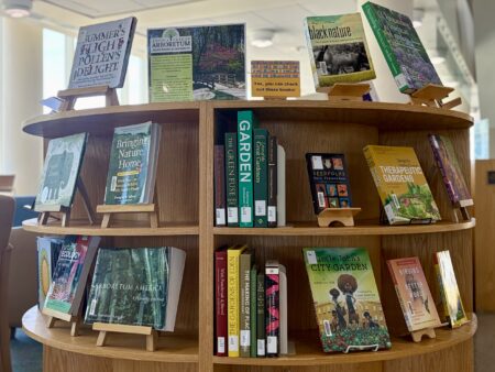 the arboretum book display on a curved shelf in rose library at jmu